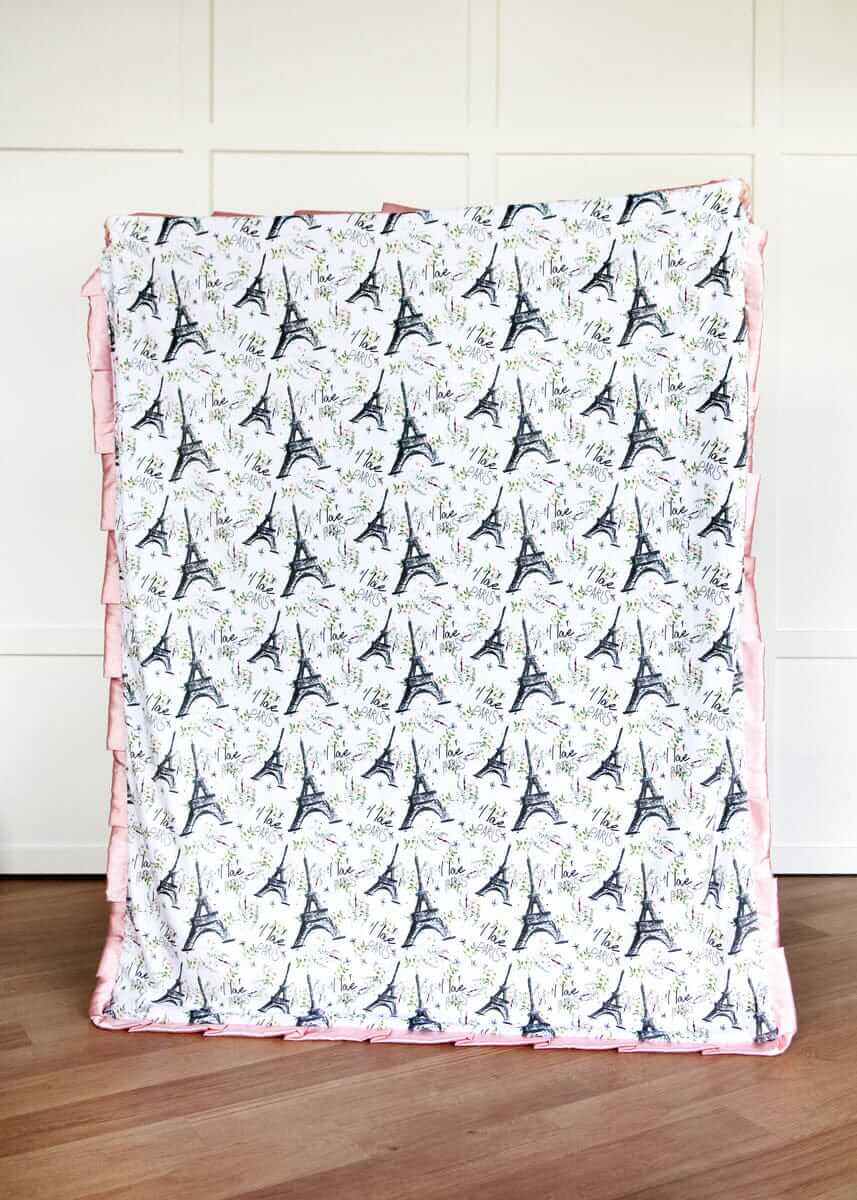 I Love Paris Blanket with Eiffel Tower pattern on a wooden floor.