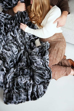 Couple cozying up with the Hugs Marble Onyx weighted blanket, featuring a plush design and modern marble print.