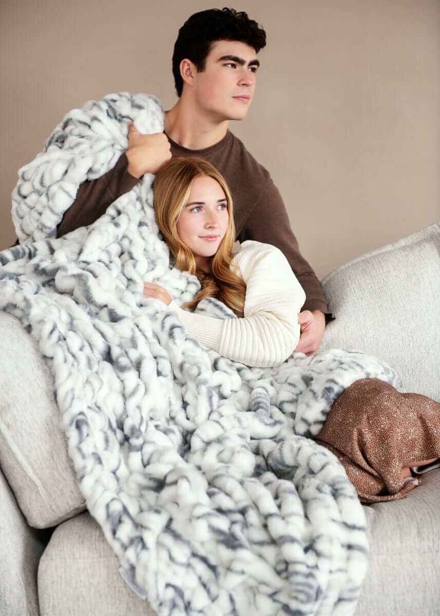 Couple cozying up under the Hugs Marble Pewter Blanket, showcasing its plush and elegant design.