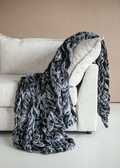 Hugs Marble Onyx weighted blanket draped over a modern couch, showcasing plush fabric and elegant marble design.