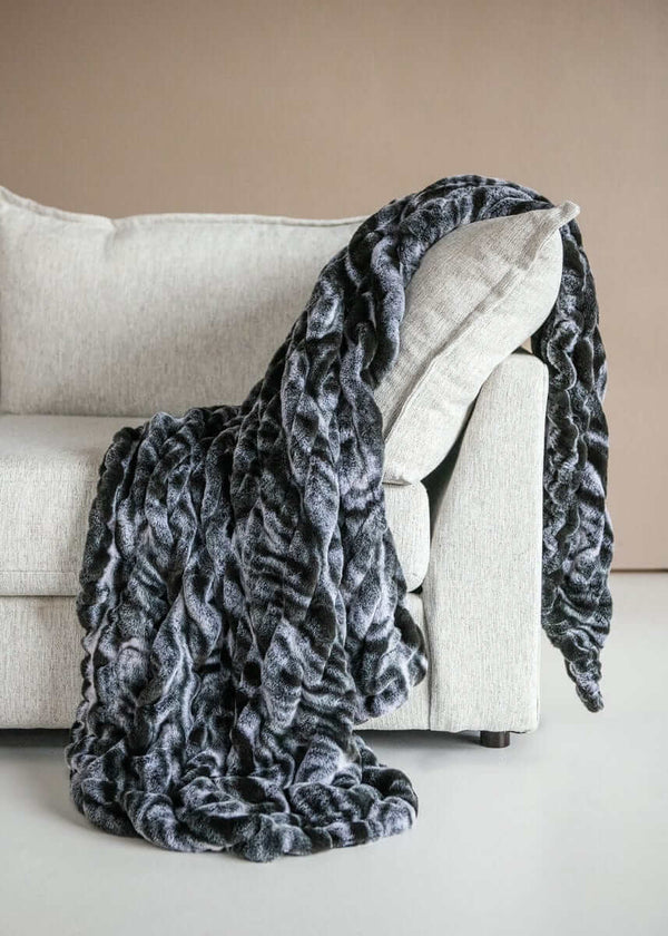 Hugs Marble Onyx weighted blanket draped over a modern couch, showcasing plush fabric and elegant marble design.