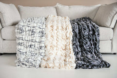 Hugs Marble Onyx Blanket displayed on a cozy couch, showcasing modern comfort with plush textures and stylish designs.