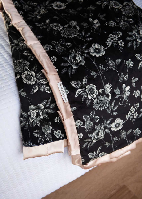 Minky Couture Black Moody floral fabric with champagne trim on a white surface.