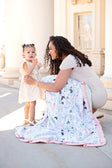 A mother and child enjoying the Spring Wildflower Blanket outdoors, showcasing its colorful floral design.