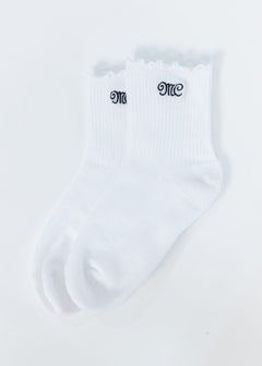 A pair of white ribbed ankle socks with scalloped edges and black embroidered MC Minky Couture lettering on the cuffs, displayed on a clean white background.