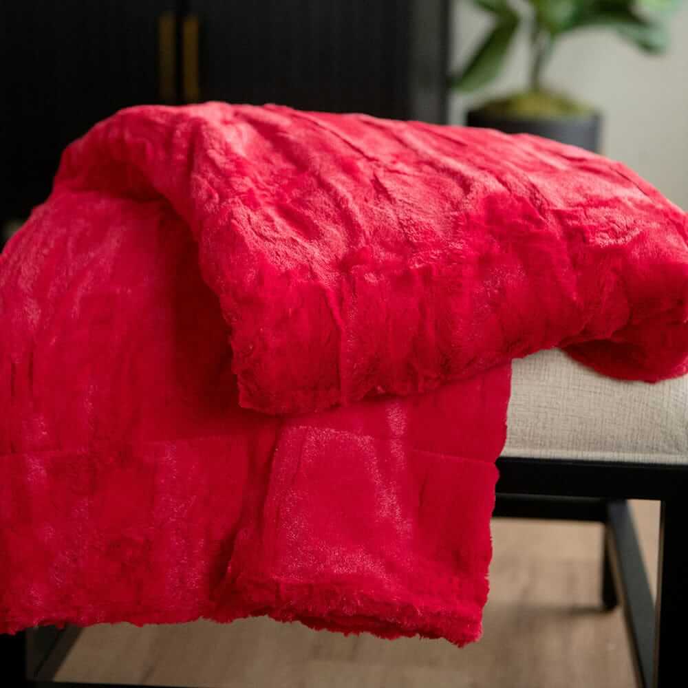 Red Minky Couture blanket draped over a bench, showcasing its plush texture and vibrant color.