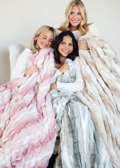 Cozy Hugs Swirl Blankets on three women wrapped in plush, stylish blankets for warmth and comfort.