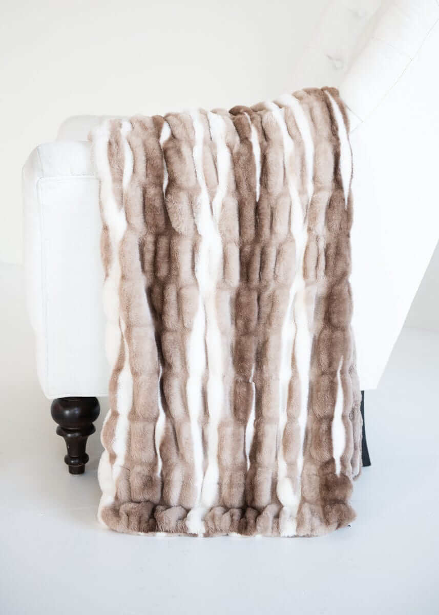 Cozy White Glove Hugs Swirl Hot Chocolate Minky Couture throw blanket draped over a white chair.