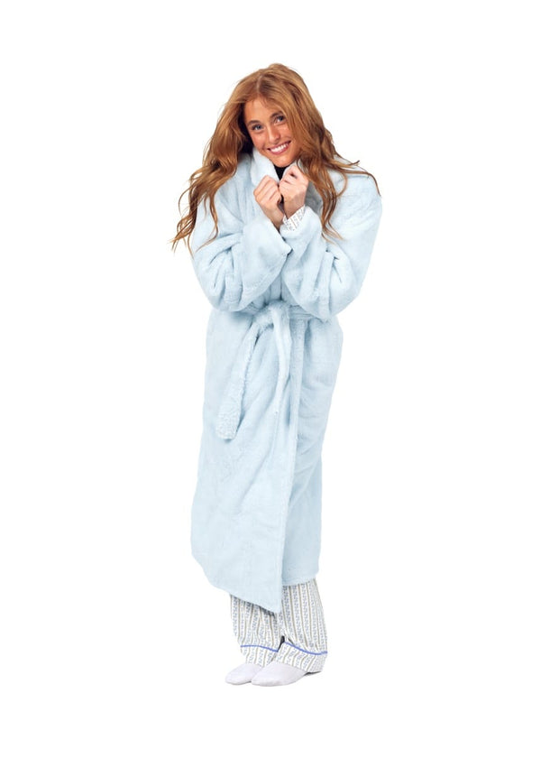 A woman with long red hair wearing a light blue plush bathrobe and striped pajama pants, standing against a solid white background.