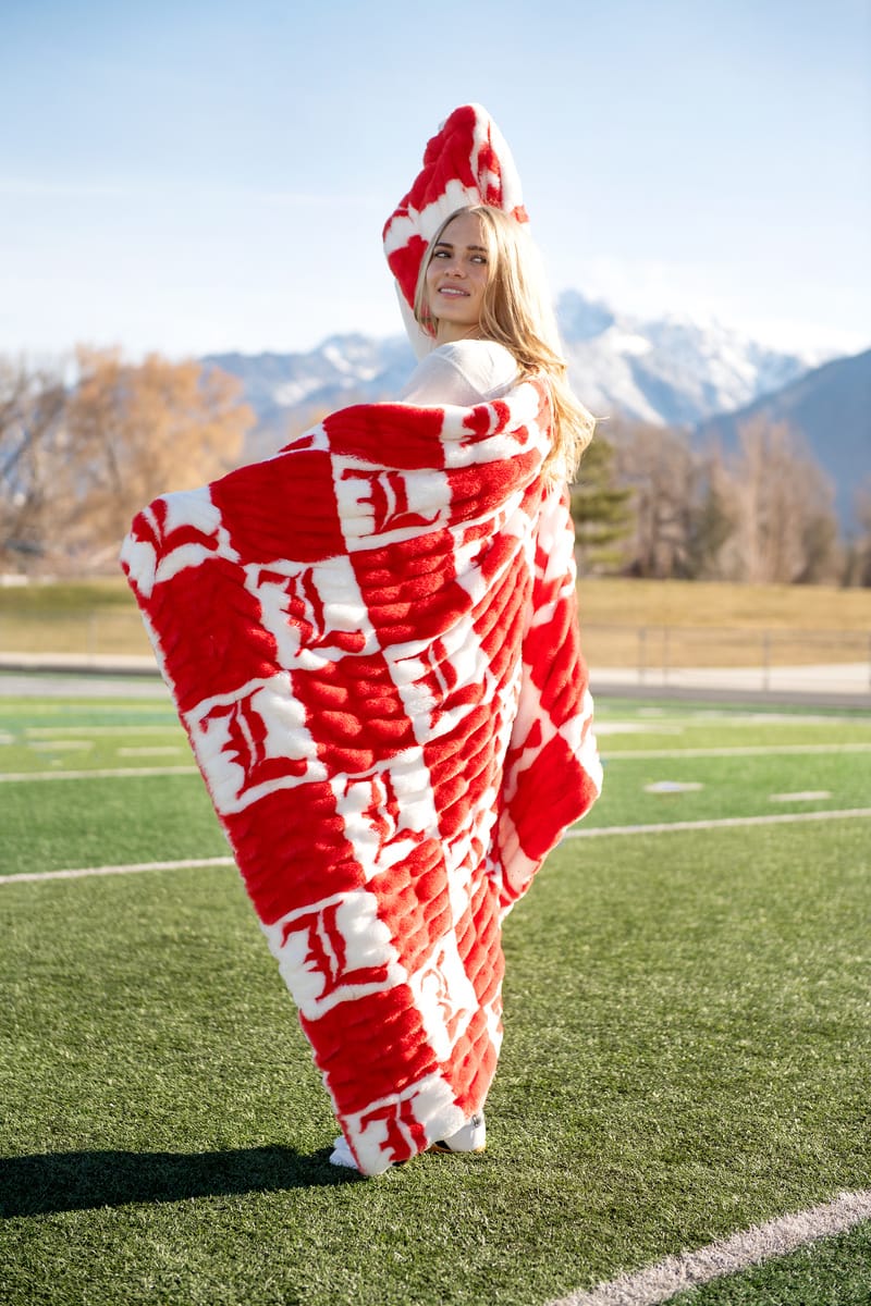 University of Louisville Blanket being modeled outdoors with mountains in the background, showcasing vibrant colors.