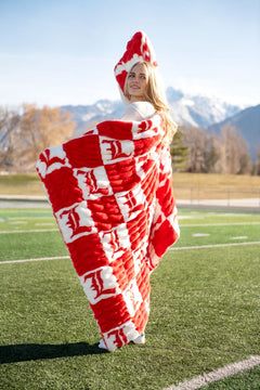 University of Louisville Blanket being modeled outdoors with mountains in the background, showcasing vibrant colors.