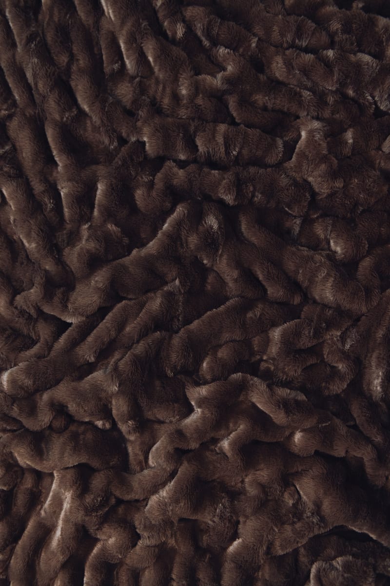 A close-up of dark brown plush Minky fabric with a textured, wavy pile.