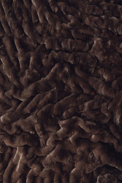 A close-up of dark brown plush Minky fabric with a textured, wavy pile.