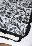 Toile black and white patterned fabric with classical design on a white background.