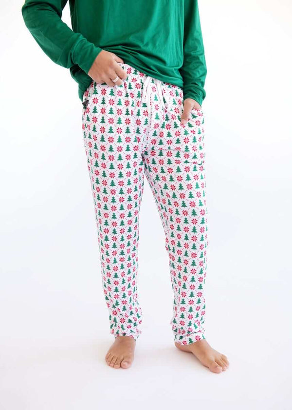 Close-up of man with Minky Couture green long-sleeve top and white Christmas tree pajama jogger.