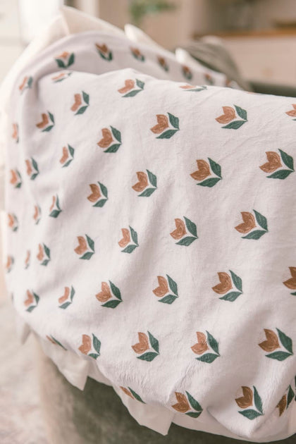 Floral patterned fabric draped over a chair with a blurred background