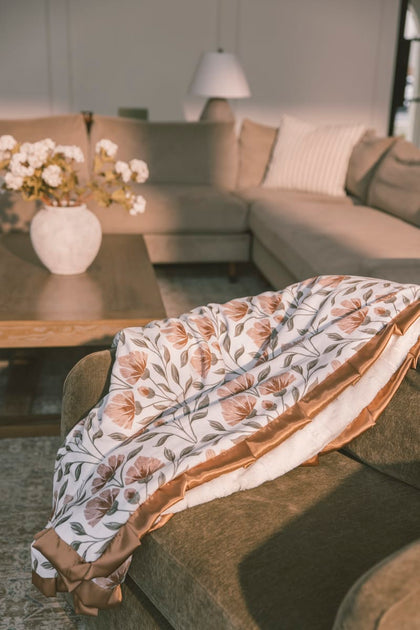 Cozy living room featuring the Flower Garden Blanket draped over a sofa with floral print and plush backing.