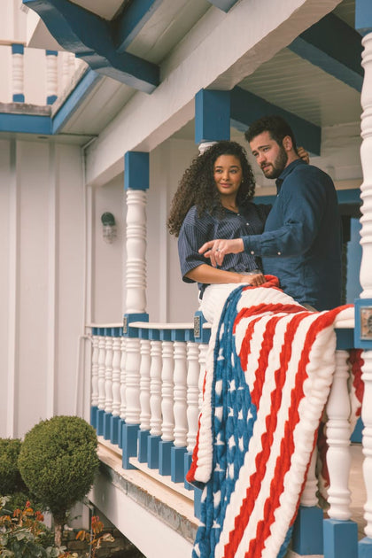 Two people on a porch with an American flag blanket