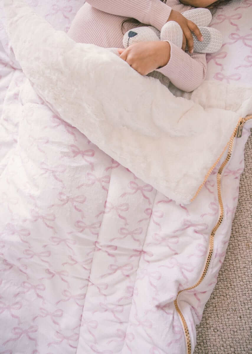 Sleeping Bag Pretty Pink Bows with plush Minky lining and zipper, featuring a child cuddling a toy.