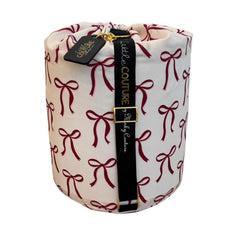 Red ribbon bows baby sleeping bag rolled with black Little Couture strap and gold hardware.