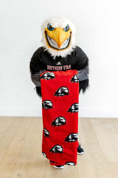 Southern Utah Thunderbirds mascot holding red Minky blanket with eagle logos.