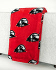 Red Southern Utah Thunderbirds blanket draped over light gray sofa.