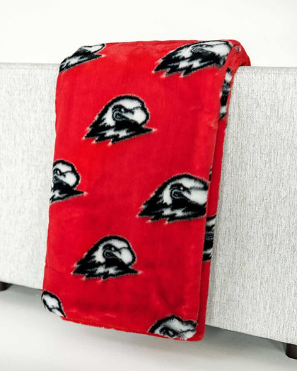 Red Southern Utah Thunderbirds blanket draped over light gray sofa.