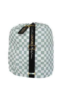 Sleeping Bag Sage Check rolled up and secured with strap, featuring a stylish sage check pattern.