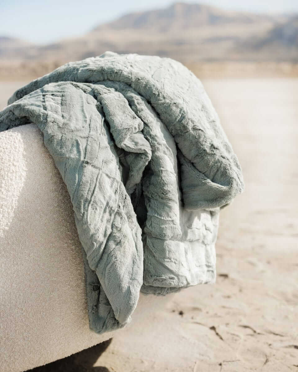 Sorbet Mist Blanket draped over a textured surface in a soothing green hue, perfect for cozy spaces.