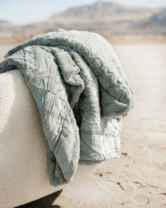 Sorbet Mist Blanket draped over a textured surface in a soothing green hue, perfect for cozy spaces.