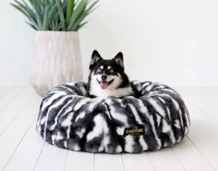 Happy dog resting in a Cloudy Day Black Pet Bed, made with orthopedic memory foam and Minky Couture fabric.
