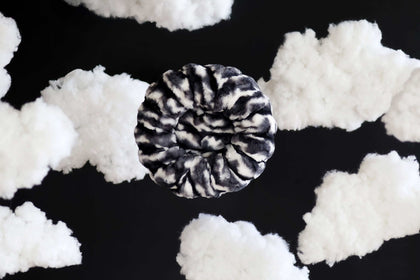 Cloudy Day Black Pet Bed surrounded by fluffy clouds, perfect for pet snuggling and comfort.
