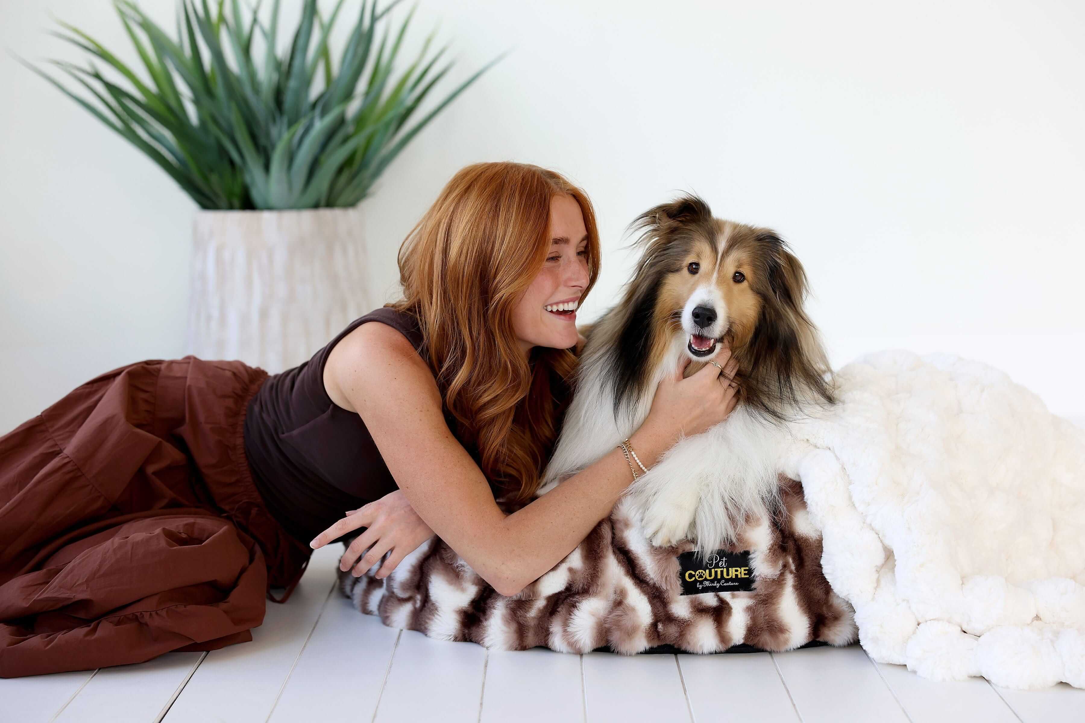 Woman smiling with her dog on the Cloudy Day Brown Pet Bed, showcasing comfort and style.