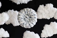 Cloudy Day Blue Pet Bed surrounded by fluffy clouds, offering cozy comfort and orthopedic support for pets.