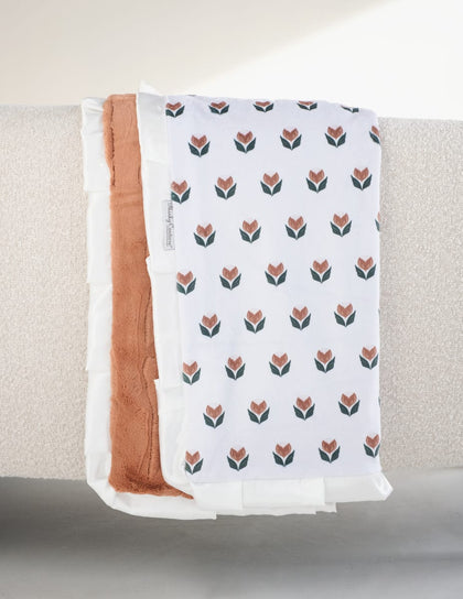 Tulip Garden Blanket displayed with a cream background and tulip pattern, featuring a hazelnut plush backing and evergreen ruffle.