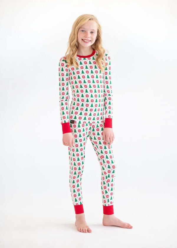 Girl standing in Christmas Minky Couture pajamas with red cuffs.