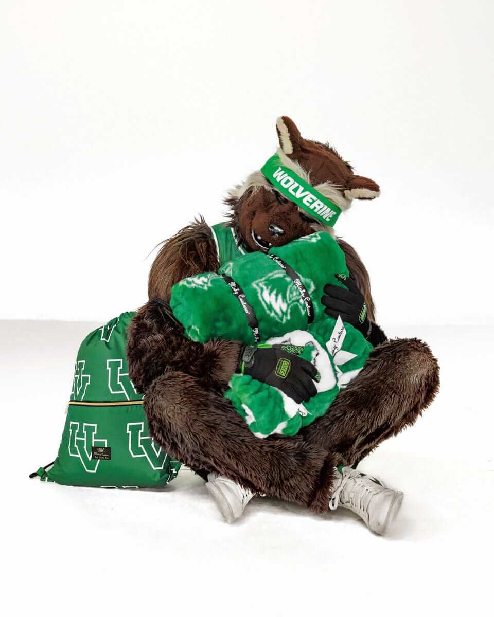 Utah Valley Wolverines mascot hugging a green Minky Couture collegiate blanket in a studio setting.