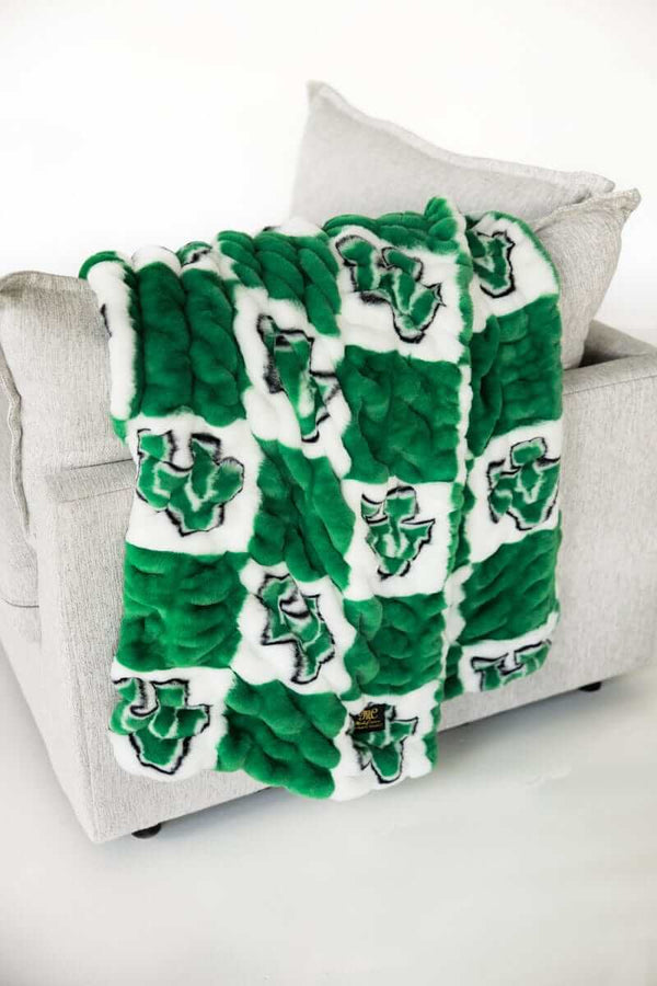 Green and white Utah Valley Wolverines checkered blanket draped over light gray armchair.