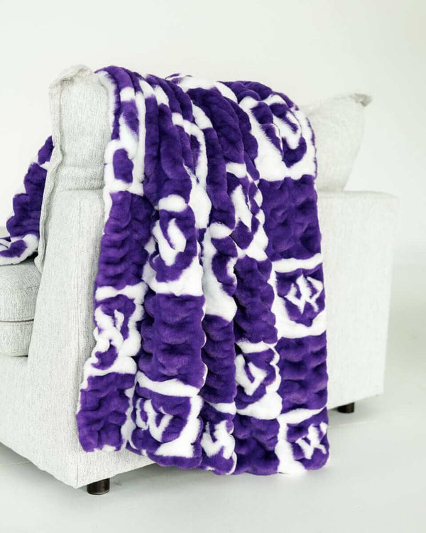 Purple and white checkered Weber State Wildcats blanket draped over light gray chair.