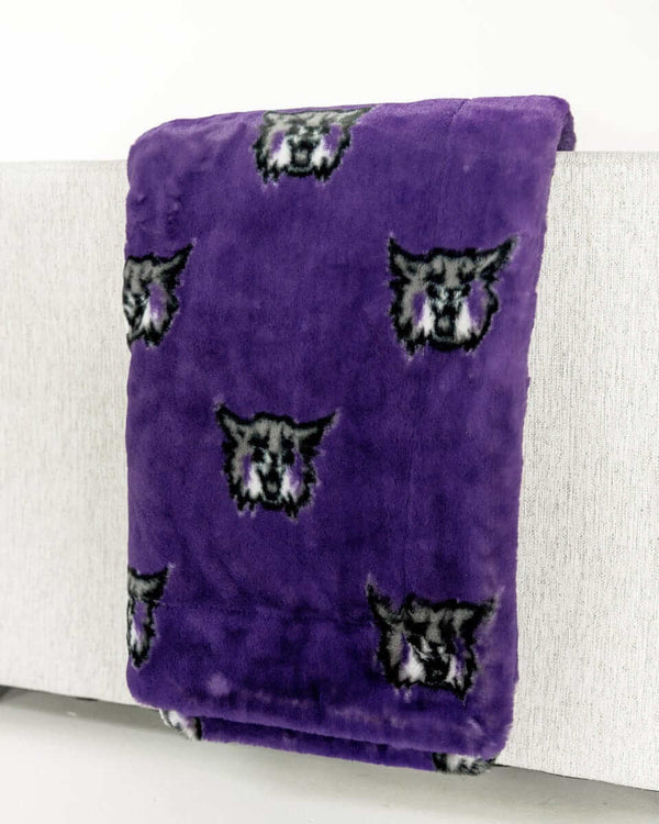Purple Weber State Wildcats throw blanket with repeating wildcat head logos draped over a light sofa.