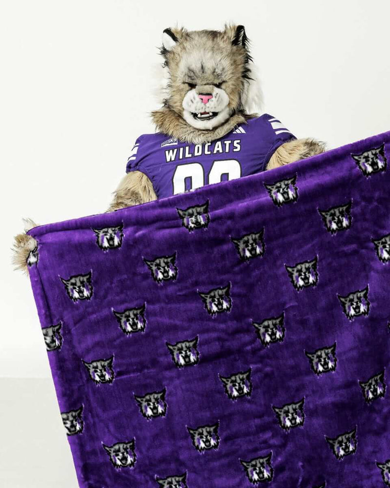 Weber State Wildcats mascot holding purple blanket with repeated wildcat logo pattern.