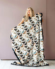 Stallion Blanket featuring watercolor horses on cream, held by a woman against a pink wall, ideal for cowboy themes.