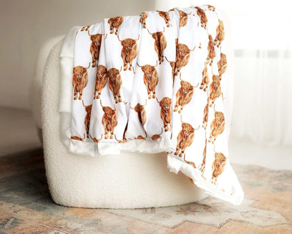 Highland Cow Blanket featuring highland cows on white with a creamy satin ruffle, perfect for rodeo lovers.