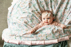 Baby girl wrapped up in a Blushing Blue blue floral patterned Minky Couture blanket.