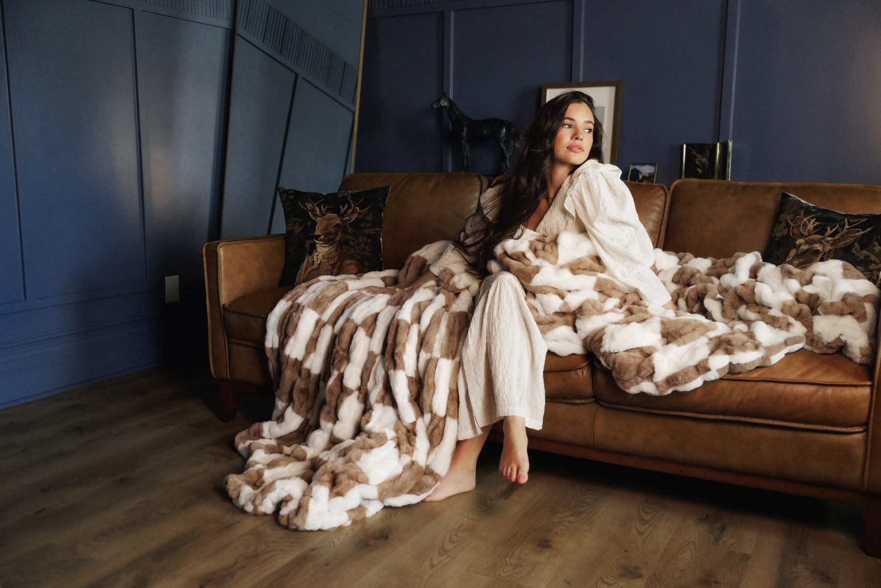 Stylish setting featuring the Hugs Check Milk Chocolate Blanket draped over a cozy couch.