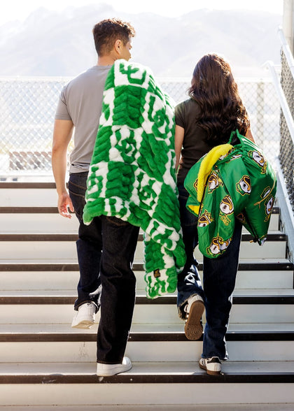 University of Oregon Ducks Blanket wrapped around friends walking up steps, showcasing vibrant green and team spirit.
