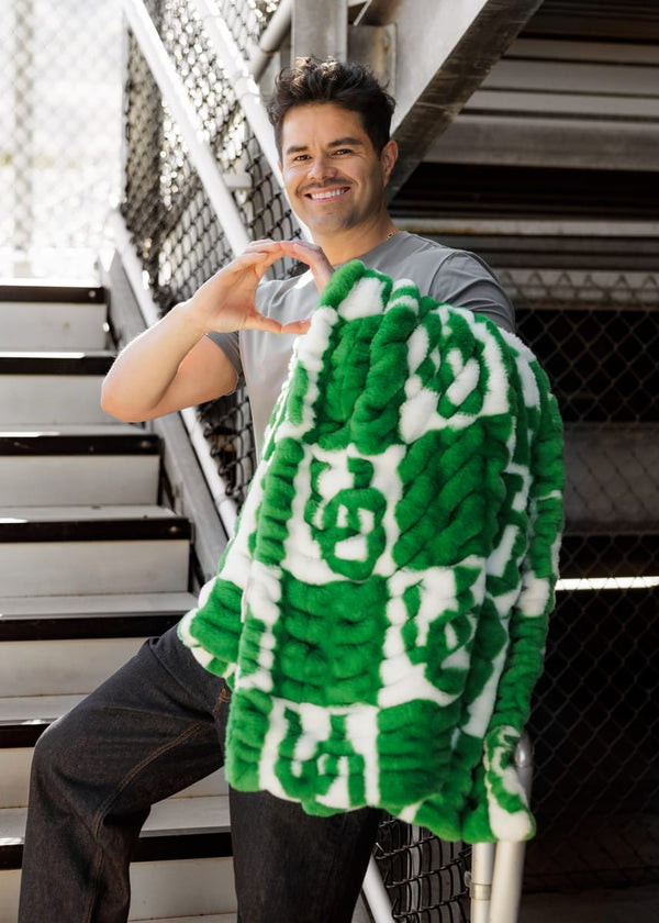 Man showing love for the University of Oregon Ducks Blanket while sitting on stairs.