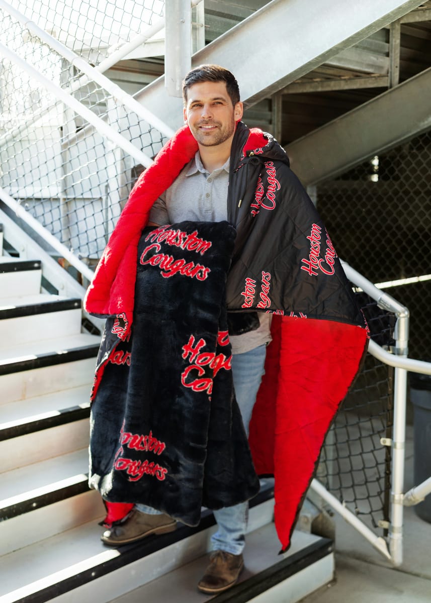 Houston Cougars Blanket - Lush draped over a man, showcasing its cozy design and bold team spirit.