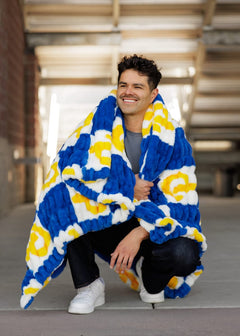 Young man wearing the University of Pittsburgh Panthers Blanket, cozy and stylish in deep navy and bright yellow.