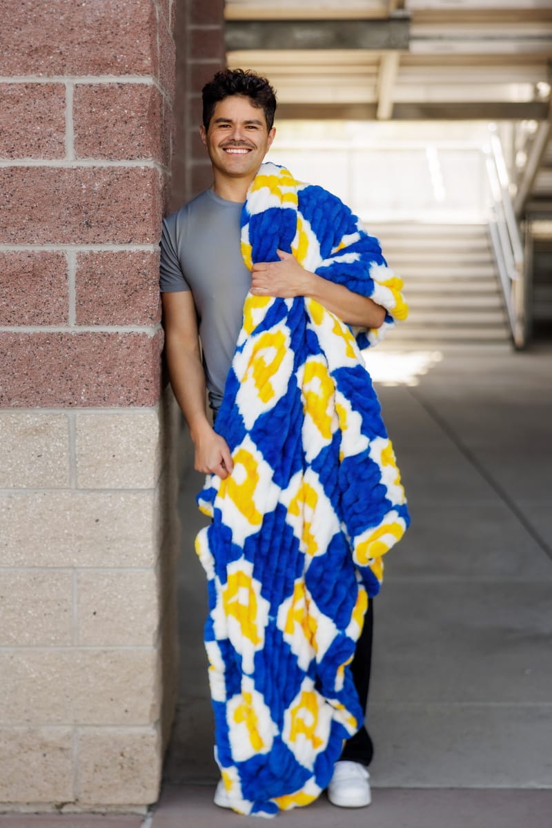 University of Pittsburgh Panthers Blanket displayed by a smiling man, showcasing its plush fabric and vibrant colors.